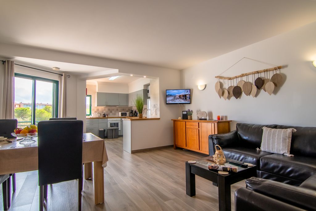 Luminoso y acogedor salón con amplio sofá cómodo y zona de comedor.