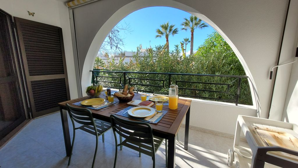 Balcón con arco y mesa exterior en Apartamento Noa Mar, Salgados