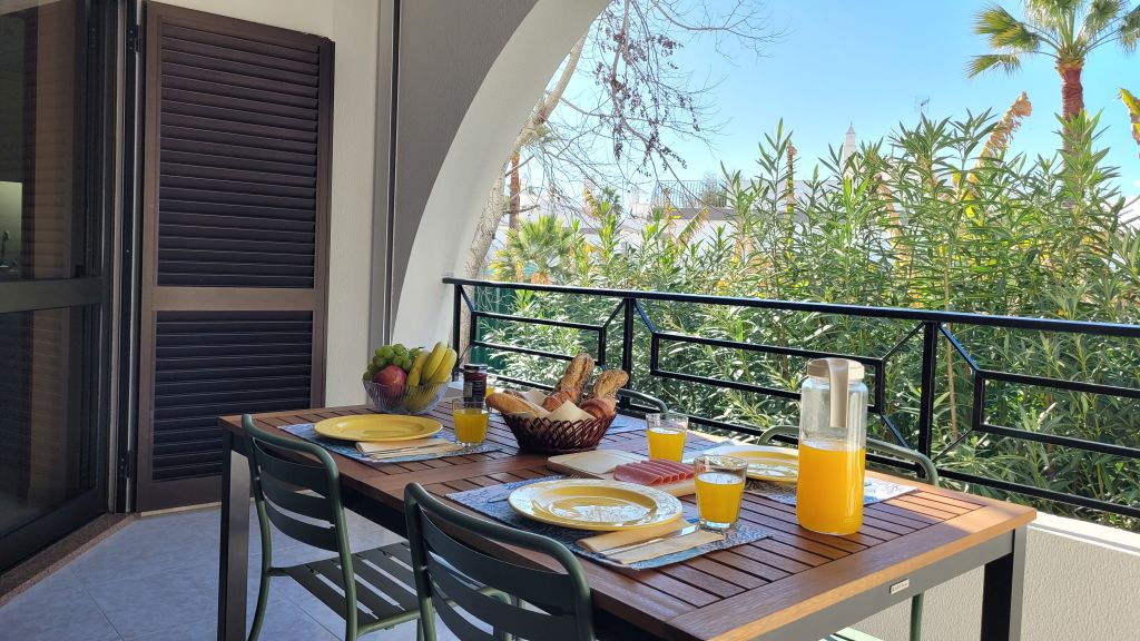 Balcón soleado preparado para el desayuno en Apartamento Noa Mar con vistas a zonas verdes en Salgados